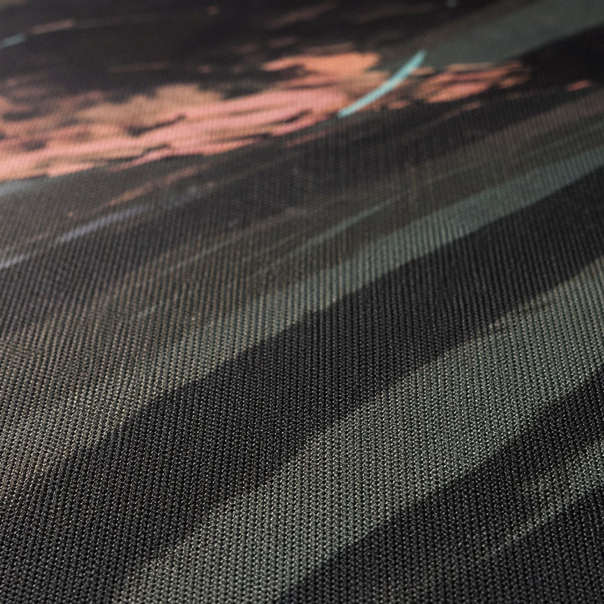 Close-up of the woven cloth top of a custom mouse pad showing the printed design in the weave