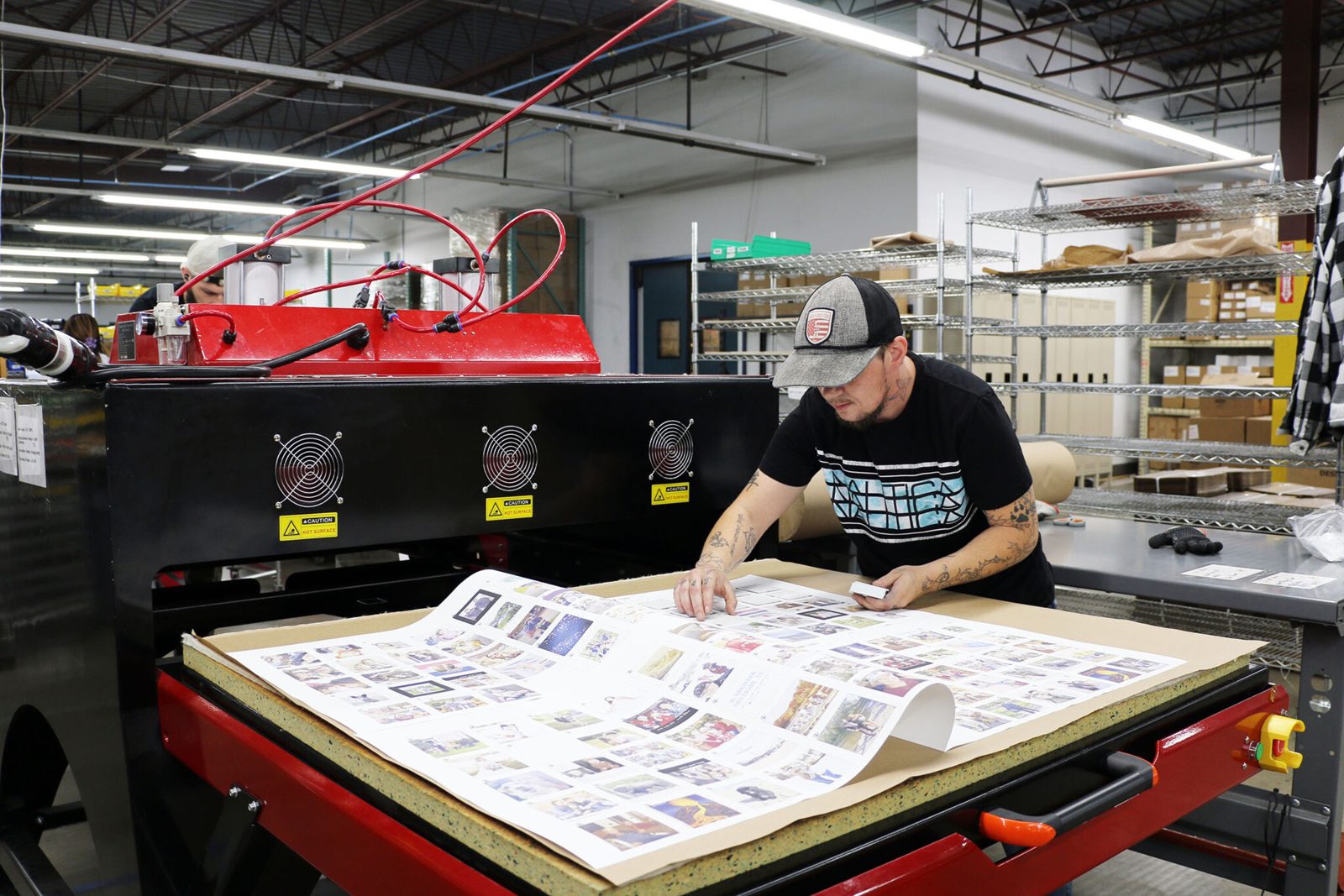 Custom desk mats being pressed on a large-format sublimation press in the W&H Custom Co print shop